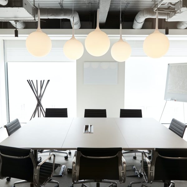 Chairs Around Boardroom Table In Empty Modern Meeting Room